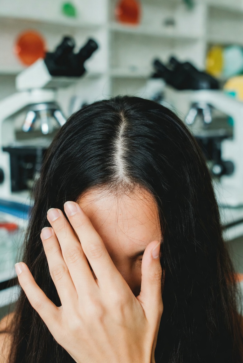 Young mother brushing hair with visible regrowth