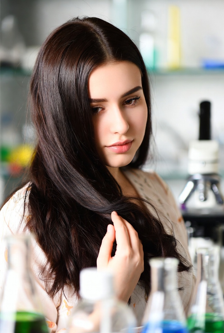 Person applying detox scalp treatment with dropper